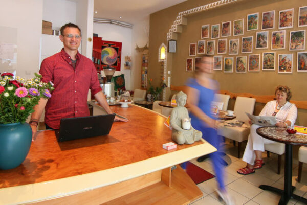 Yogalehrer Stefan Datt begrüßt an der Rezeption im Yoga-Studio in Berlin-Charlottenburg